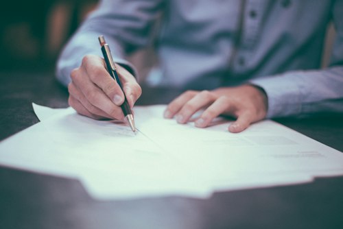 Business owners signing term loan paperwork with an advisor